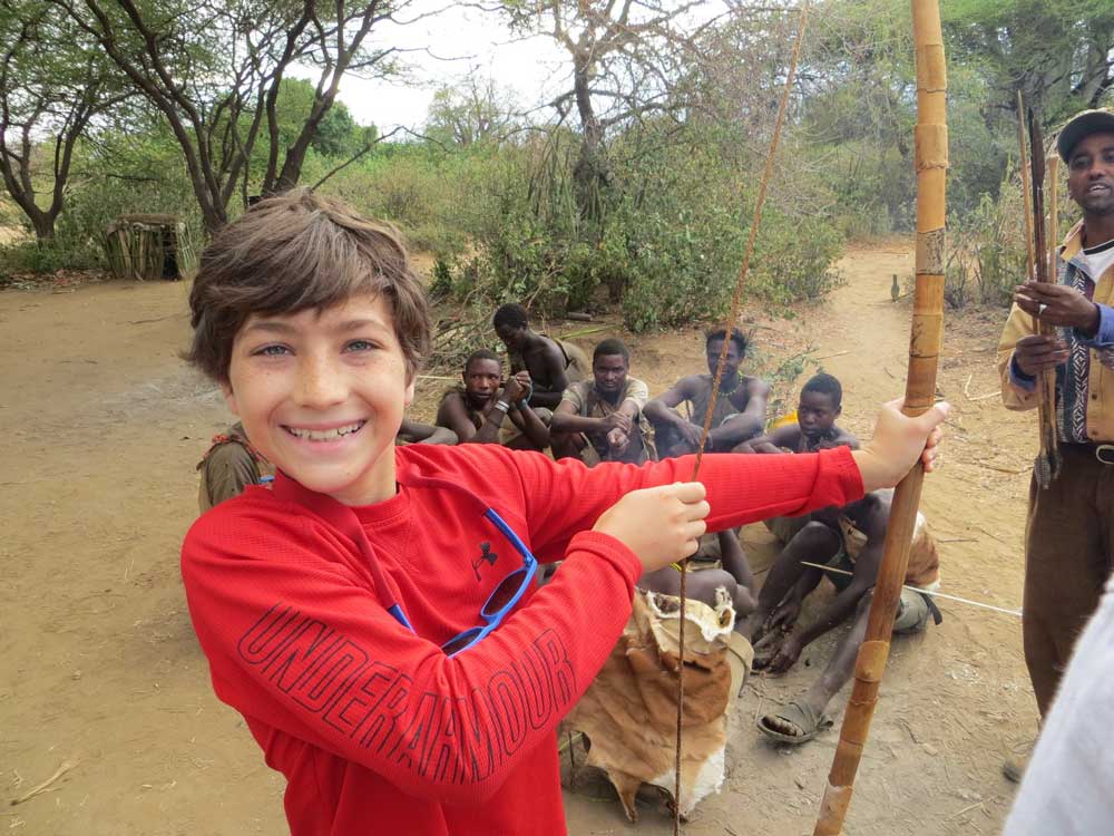 Young traveler experiences a modern day connection to our ancient indigenous roots with the Hadza bushmen of Tanzania. Courtesy Wildland Adventures.